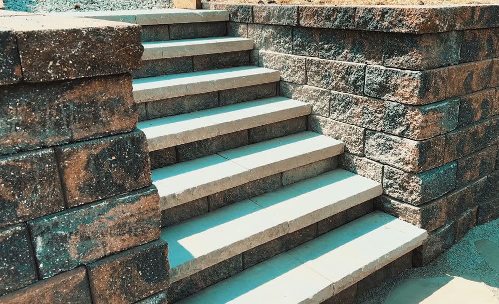 Paved stone steps leading up with textured retaining walls in natural light.