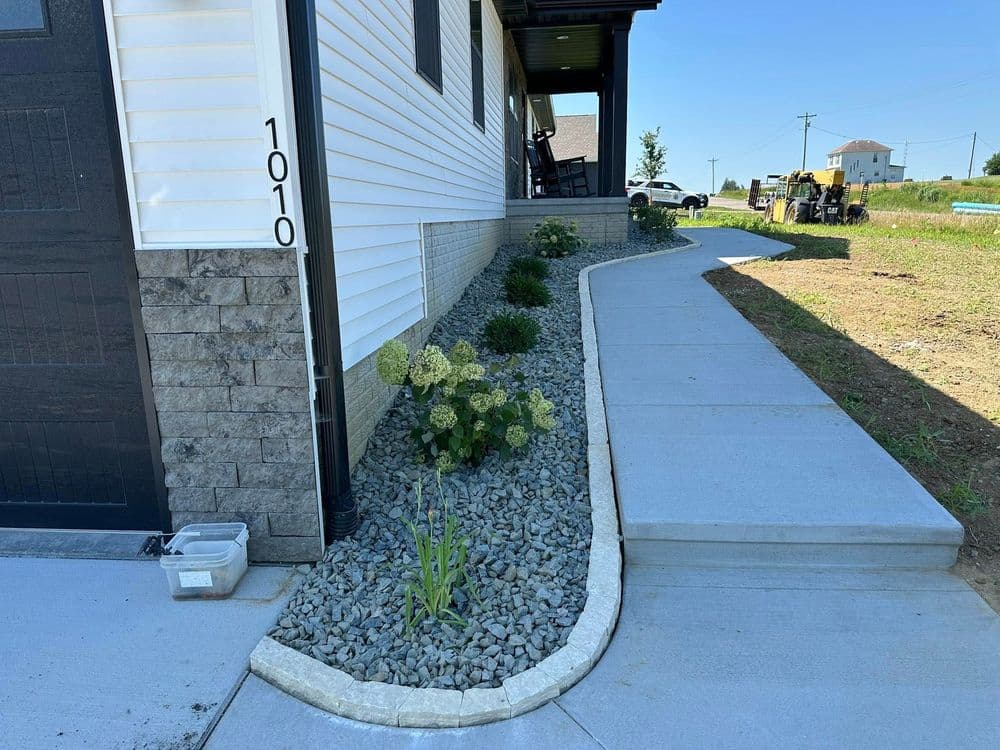 House exterior with stone pathway and landscaped garden featuring gravel and plants.